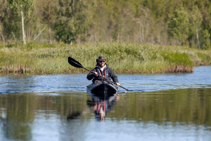 a man standing next to a body of water