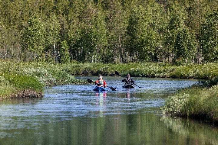 a group of people rowing a boat in a body of water